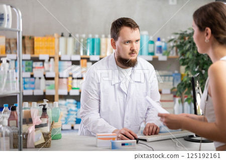Man pharmacist looking for prescription on computer for buyer 125192161