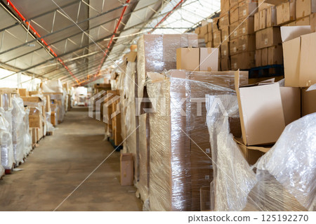 Rows of pasteboard boxes on racks in storehouse Rows of pasteboard boxes on racks in storehouse 125192270