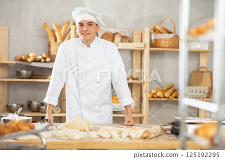 Young guy standing in bakehouse, ready to start baking Young guy standing in bakehouse, ready to start baking 125192295