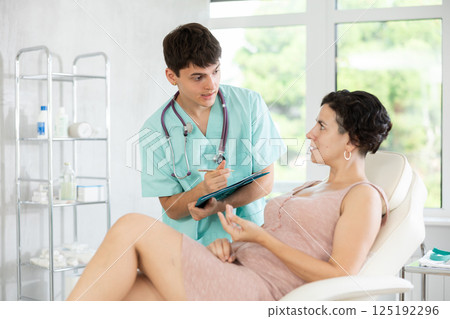 Doctor cosmetologist writes down the complaints of female patient in cosmetology clinic 125192296