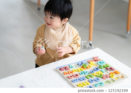 1 year old boy doing alphabet puzzle 125192399