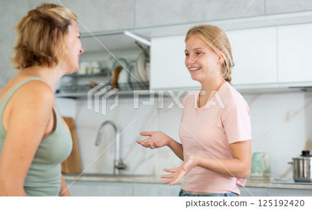 Teenage daughter enthusiastically tells unrecognizable mother about planned vacation with friends Teenage daughter enthusiastically tells unrecognizable mother about planned vacation with friends 125192420