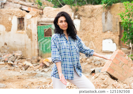 Woman in the courtyard of destroyed house Woman in the courtyard of destroyed house 125192508