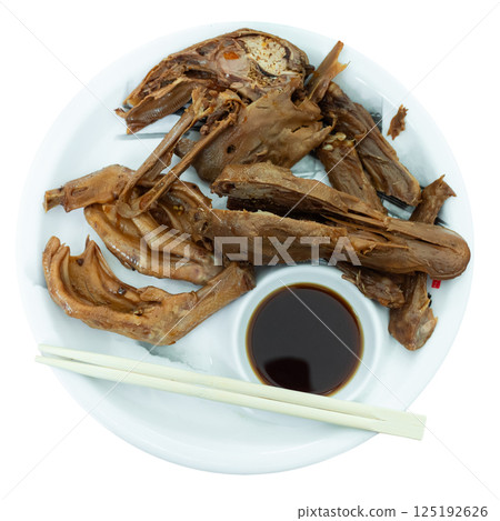 Portion of fried boiled parts of duck carcass is laid out on plate - paws, wings, head Portion of fried boiled parts of duck carcass is laid out on plate - paws, wings, head 125192626