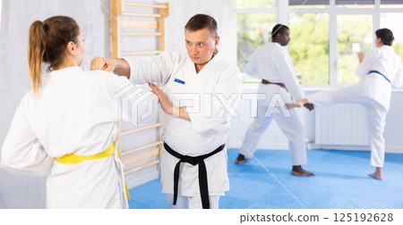 Adult man and adult woman training karate techniques Adult man and adult woman training karate techniques 125192628