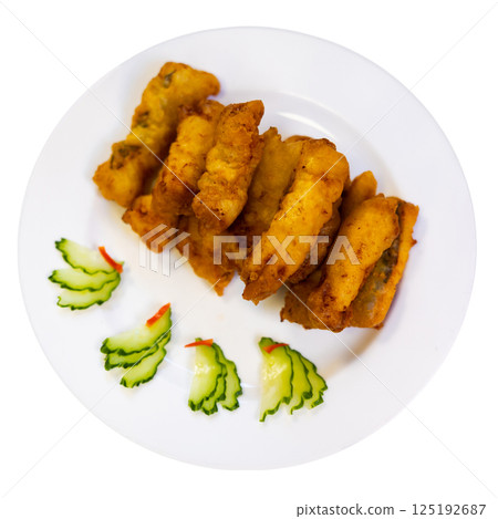 Pieces of eel fillet, fried to crispy crust, garnished with cucumber slices Pieces of eel fillet, fried to crispy crust, garnished with cucumber slices 125192687