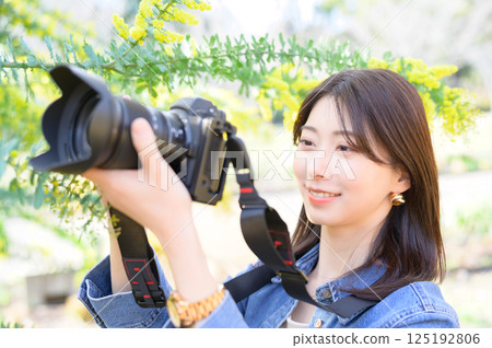 Young female photographer photographing flowers 125192806