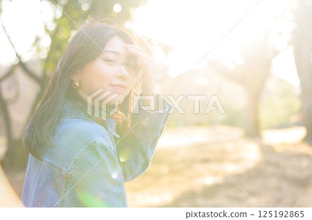 Young woman looking back in the sun Young woman looking back in the sun 125192865