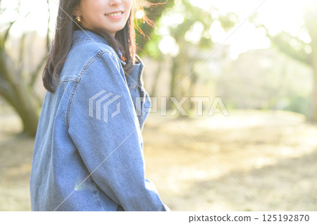 Young woman looking back in the sun Young woman looking back in the sun 125192870