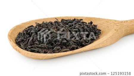 Dry black tea leaves in wooden spoon isolated on white background Dry black tea leaves in wooden spoon isolated on white background 125193158