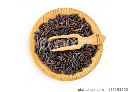 Black wild rice in wooden bowl and scoop isolated on white background close up. Top view. Flat lay 125193200