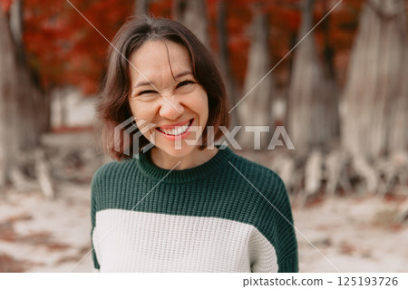 Portrait of smiling woman in autumn park. Stylish woman with happy emotions Portrait of smiling woman in autumn park. Stylish woman with happy emotions 125193726