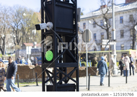 A tram traffic light which has a green light illuminated on it right now 125193766