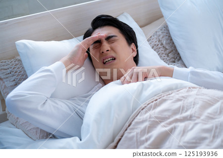 Unwell young man sleeping in bed 125193936