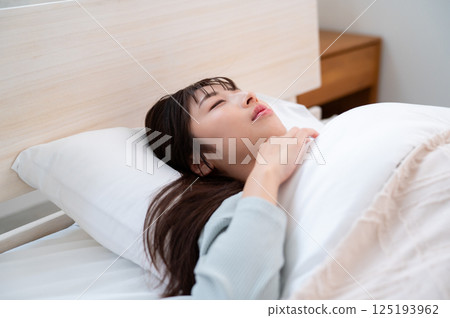 A young woman sleeping in bed 125193962