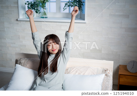 Young woman stretching in bed 125194010