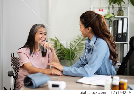 Emotional Support and Patient Interaction. A nurse comforts an elderly woman during a health consultation. Emotional Support and Patient Interaction. A nurse comforts an elderly woman during a health consultation. 125194269