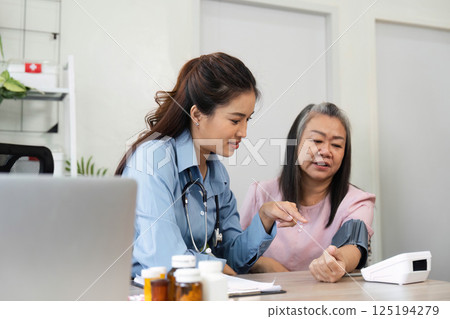 Patient Education and Support. A nurse explains health information to an elderly patient. 125194279