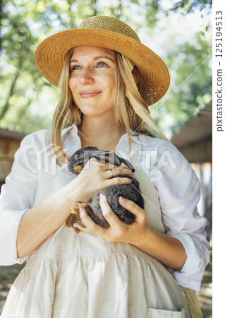 Close up of a young beautiful woman holding a small black rabbit 125194513