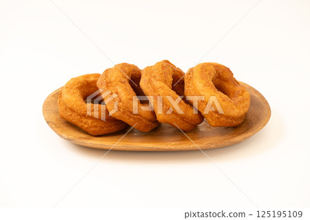 Delicious donuts on a wooden plate 125195109