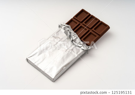 Chocolate bar with the foil peeled off, white background 125195131