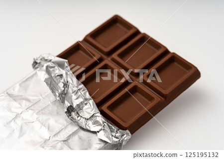 Chocolate bar with the foil peeled off, white background 125195132