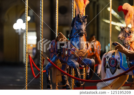 Vintage carousel horse at nighttime with illuminated background 125195209