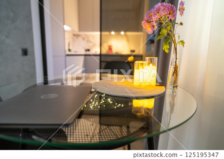 Laptop, Home Office, Evening: Modern apartment workspace, illuminated, cozy ambiance, laptop on glass table, showing evening work or relaxation. Laptop, Home Office, Evening: Modern apartment workspace, illuminated, cozy ambiance, laptop on glass table, showing evening work or relaxation. 125195347
