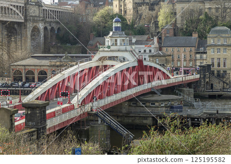 A view of The Iconic Swing bridge spanning the River Tyne with historical buildings at the background. A view of The Iconic Swing bridge spanning the River Tyne with historical buildings at the background. 125195582