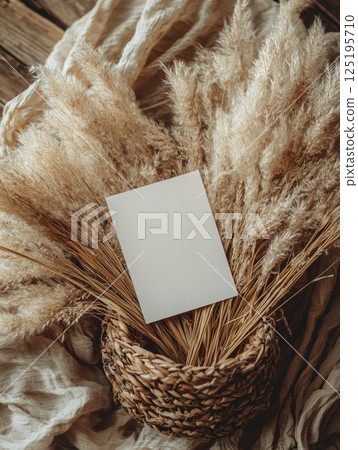 Blank A5 card on dried pampas grass in rustic basket 125195710