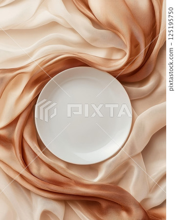 White plate on flowing beige fabric White plate on flowing beige fabric 125195750