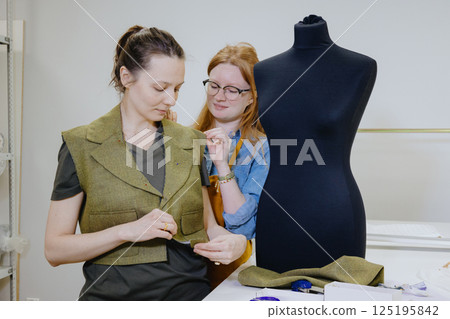 Atelier sewing workshop. female seamstress, fashion designer, takes measurements . 125195842
