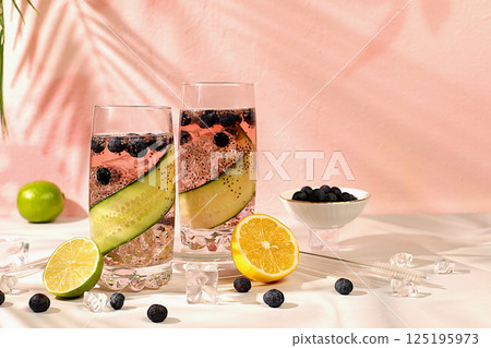Diet vegan cocktail with cucumber, lemon, lime, blueberry and chia seeds, detox diet and weight loss concept, healthy lifestyle and healthy food advertising, cafe menu. Modern still life with drinks. 125195973
