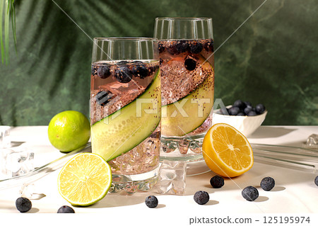 Modern still life with drinks. Diet vegan cocktail with cucumber, lemon, lime, blueberry and chia seeds, detox diet and weight loss concept, healthy lifestyle and healthy nutrition advertisement, 125195974