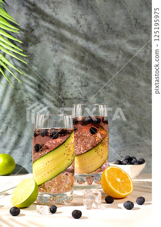 Cold homemade lemonade or cocktail with chia seeds, blueberries, lemon, cucumber and lime on a sunny table, Detox diet and summer party concept. Refreshing summer drink recipe, restaurant menu Cold homemade lemonade or cocktail with chia seeds, blueberries, lemon, cucumber and lime on a sunny table, Detox diet and summer party concept. Refreshing summer drink recipe, restaurant menu 125195975