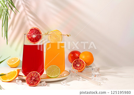 Orange juice, thick smoothie and oranges, grapefruit, lime, blood orange and lemon on elegant kitchen table. Detox diet and weight loss concept, summer vitamin drinks, Modern still life with citrus 125195980