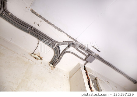 Installation of electrical wiring on the ceiling.  125197129
