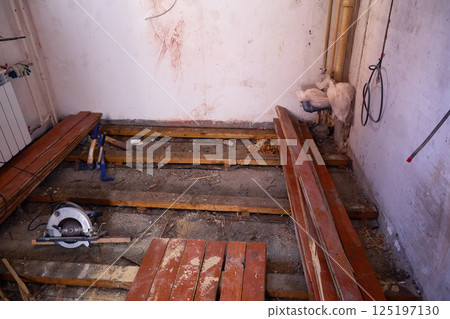 The old wooden floor has been dismantled in the room, wooden boards are lying . 125197130