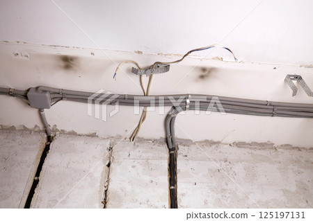 Installation of electrical wiring on the ceiling.  125197131