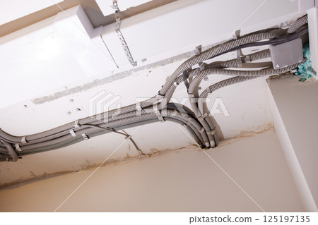 Installation of electrical wiring on the ceiling.  125197135
