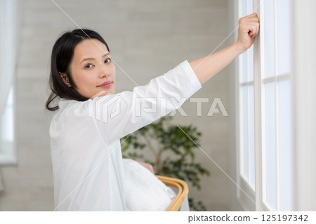 女人拿著洗衣籃打開窗戶| ©Steve Hutchins健康生活形象|幸福女孩 |福利 女人拿著洗衣籃打開窗戶| ©Steve Hutchins健康生活形象|幸福女孩 |福利 125197342