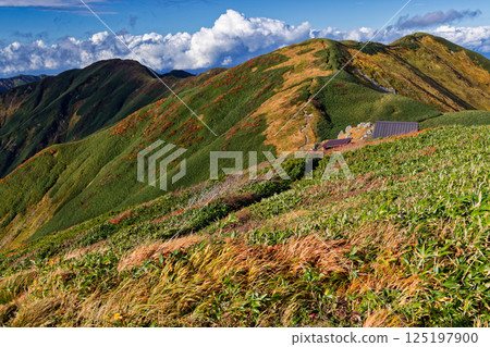 View of the Kadouchi hut and the northern ridgeline with autumn leaves from Kadouchi-dake in the Iide mountain range View of the Kadouchi hut and the northern ridgeline with autumn leaves from Kadouchi-dake in the Iide mountain range 125197900