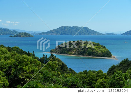 從大芝島望去,在湛藍的天空背景下,小芝島漂浮在蔚藍的瀨戶內海上。 從大芝島望去,在湛藍的天空背景下,小芝島漂浮在蔚藍的瀨戶內海上。 125198904