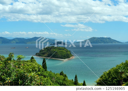 從大芝島望去，瀨戶內海上漂浮的小芝島以藍天白雲為背景。 125198905