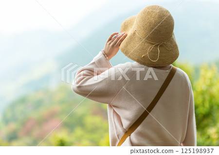 一位中年婦女從觀景台望向山 125198937
