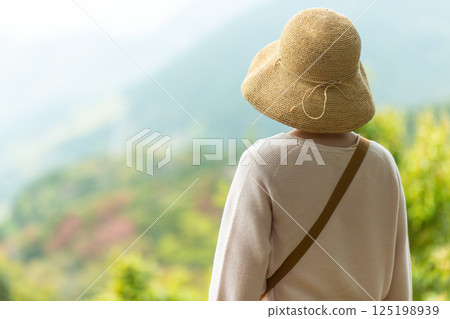 一位中年婦女從觀景台望向山 125198939