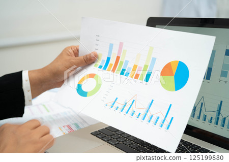 Asian business woman working with financial graph. 125199880