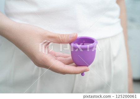 Asian woman holding menstrual cup for hygiene period cycle protection. Asian woman holding menstrual cup for hygiene period cycle protection. 125200061