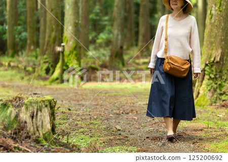 一位中年婦女在深山原始森林中行走 125200692