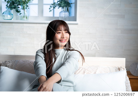 Young woman relaxing in bed Young woman relaxing in bed 125200697